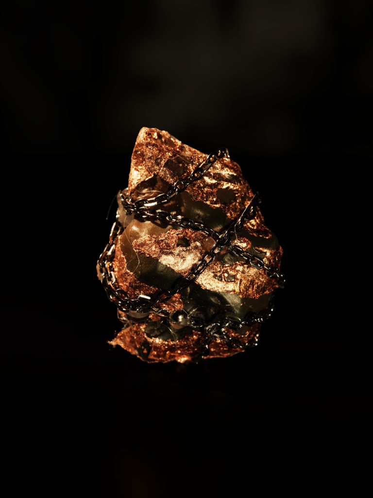 Pietra ostinata — a copper stone bound in black chain